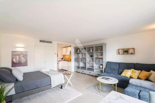 a living room with a blue couch and a table at New Large Studio - Monaco Border - Sea View - Lift - Parking included in Beausoleil