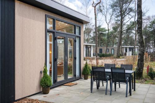 a patio with a black table and chairs at Colibri Huisje in Haarle