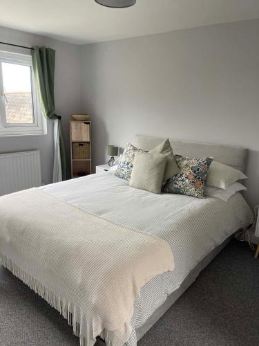 a bedroom with a large white bed with pillows at 3 Harbour Lights, Newlyn in Penzance
