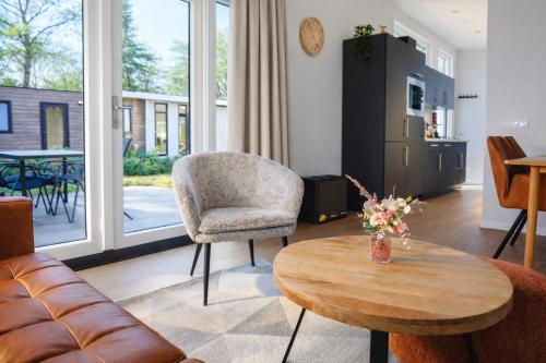 a living room with a table and a chair at Colibri Huisje in Haarle