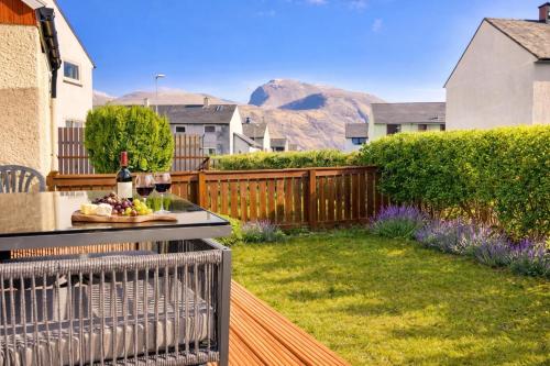 a patio with a table with a bottle of wine at Raines House - Fort William in Fort William