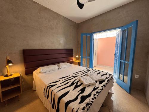 a bedroom with a large bed with a zebra print sheets at Casa Cações Beach Marataizes in Marataizes