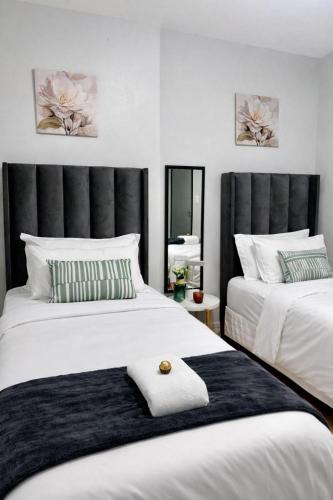 a bedroom with two beds and a mirror at Jubilee Stay in Windhoek