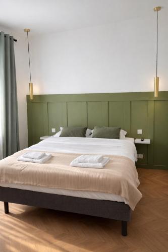 a bedroom with a large bed with a green headboard at Le Thuillat Limoges in Limoges