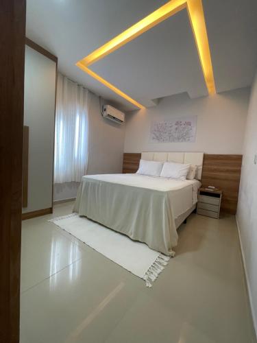 a bedroom with a large bed and a large window at Casa Lima Premium in Arapiraca