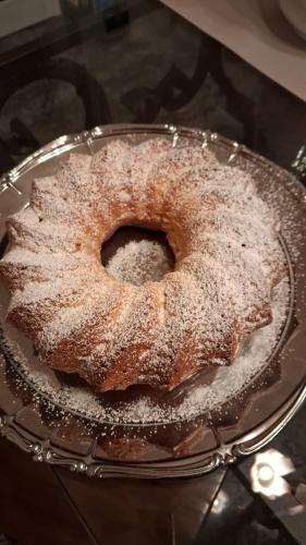a bundt cake with powdered sugar on a glass plate at Hotel Gentile in Noli