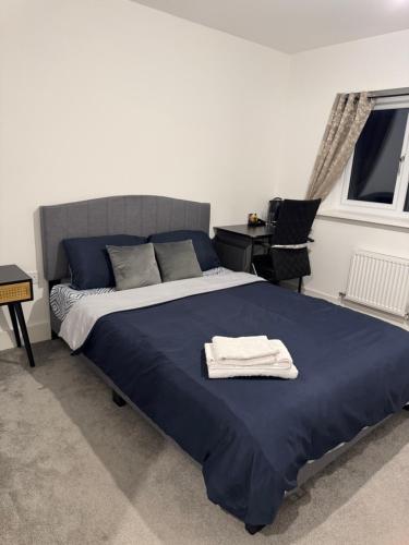 a bedroom with a bed with a blue blanket at Beautiful Private Ensuite Minutes to city centre in Stoke on Trent