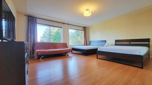 a bedroom with two beds and a couch and a chair at 7Bedroom Beautiful and spacious home in Surrey