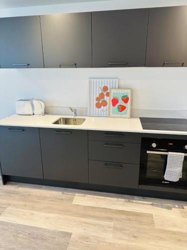 a kitchen with a sink and a stove at Stylish Modern 1-Bed Apartment in Manchester