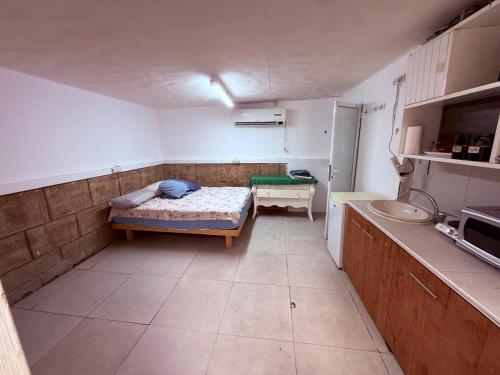 a small kitchen with a bed and a sink at ברזיליאנו - Braziliano in Eilat