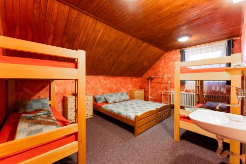 a bedroom with two bunk beds and a sink at Celá Horská Chata Maty - až 25 lůžek in Dolni Dvur