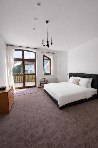 a bedroom with a large white bed and a window at Villa Grande Praha in Prague