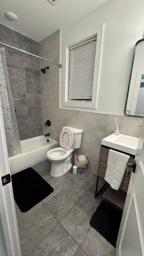 a bathroom with a toilet and a tub and a sink at Temperly Heavon in Newark