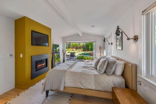 a bedroom with a large bed and a fireplace at Haven With Pool, Hot Tub And Tastings Included in Healdsburg