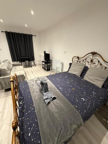 a bedroom with a bed with a blue comforter with stars on it at Private Studio near Watford Junction in Leavesden Green
