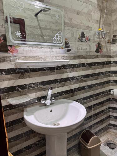 a bathroom with a white sink and a mirror at Al-Manara Hostel Siwa Oasis 2 in Siwa
