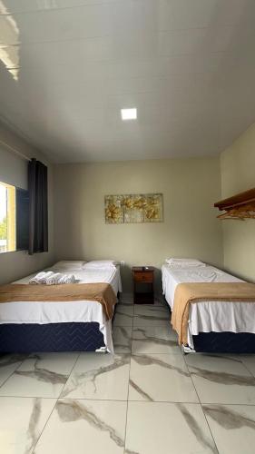 two beds in a room with a tiled floor at Loft da 14 in Soure