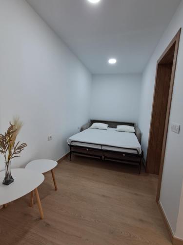 a white room with a bed and a table at Andrea's house in Charco del Pino
