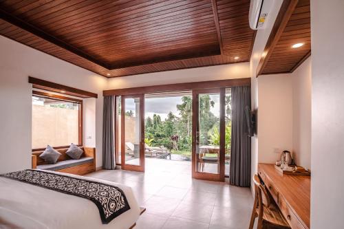 a bedroom with a bed and sliding glass doors at Taru Sebatu Villa in Ubud