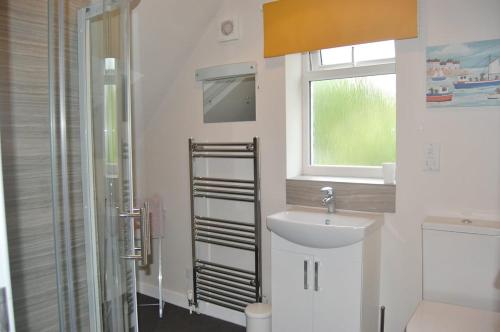 a white bathroom with a sink and a window at Gig Lodge Perfect Swanage Base in Swanage