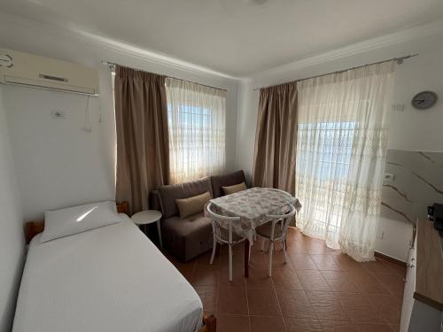 a bedroom with a bed and a table and a couch at HORIZONT Rooms in Lukovë