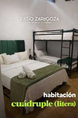 a bedroom with two bunk beds with towels at Hotel PATIO ZARAGOZA, Centro Histórico SLP in San Luis Potosí