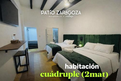 a hotel room with two beds and a desk at Hotel PATIO ZARAGOZA, Centro Histórico SLP in San Luis Potosí