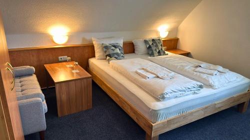 a bedroom with a large bed and a table at Hotel Relax in Wachenroth