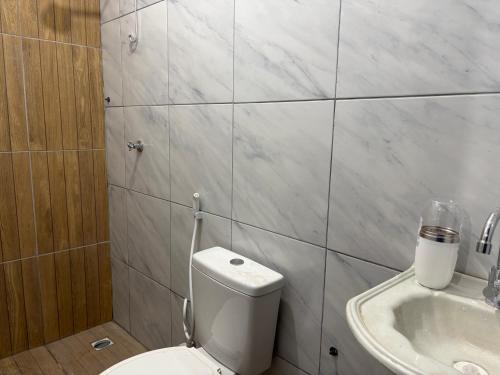 a white bathroom with a toilet and a sink at Studio suite casal in Teresina