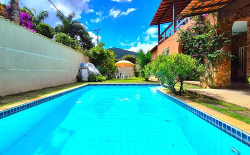 a swimming pool in front of a house at Suítes Colibri da Serra - Piscina & Conforto em Itaipava RJ in Itaipava