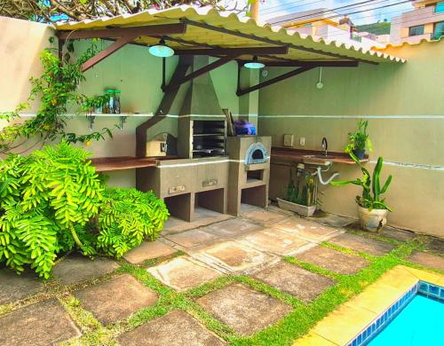 an outdoor kitchen with a table and a grill at Suítes Colibri da Serra - Piscina & Conforto em Itaipava RJ in Itaipava