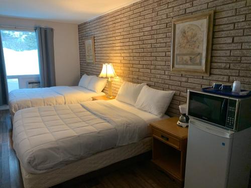 a hotel room with two beds and a tv at Spanish River Inn in Spanish