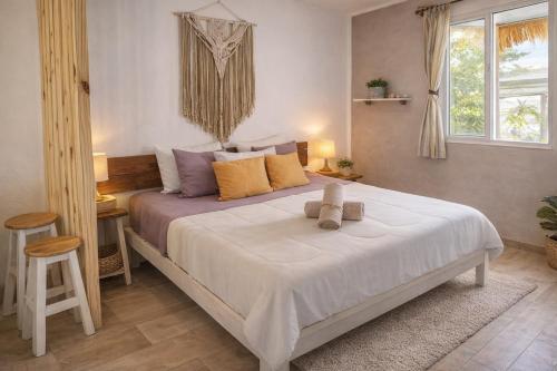 a bedroom with a large bed with yellow and purple pillows at Kika Studios in Playa del Carmen