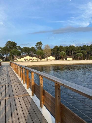 a wooden boardwalk next to a body of water at Le Trésor du Lac - Casteljaloux - Lac de Clarens - Appartement - Piscine - Parking - WIFI - Accès privée Plage - Golf - Casino - Terra Aventura - So Vélo in Casteljaloux