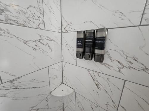a bathroom with white marble walls and two bottles at 3BR Houston with Grill, Hot Tub and Game Room near NRG, Downtown and Hobby Airport in Houston