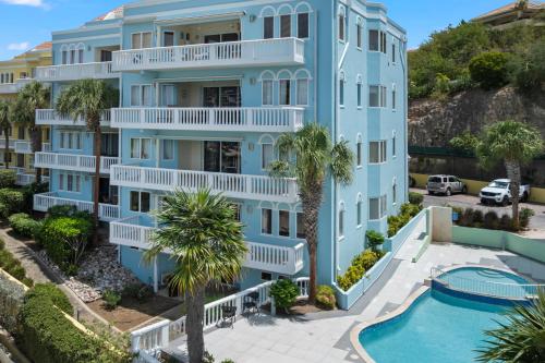 an aerial view of a blue apartment building with a swimming pool at Spacious Ocean View Apartments with Balcony in Blue Bay in Blue Bay