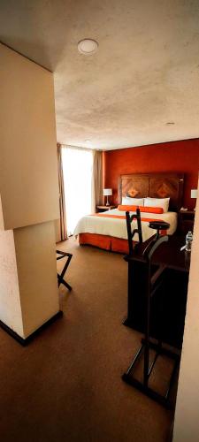 a hotel room with a bed and a desk and a bedroom at La Huerta golf & hotel in Cholula