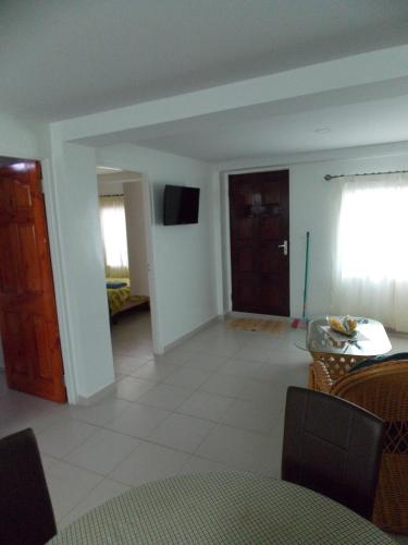 a living room with a table and a door at At Rachel in Paramaribo