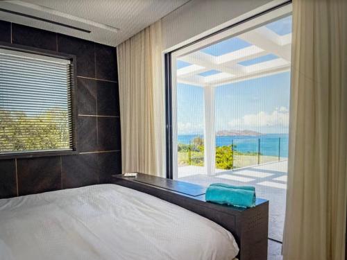 a bedroom with a bed and a large window at private villa with private pool in Aborlan