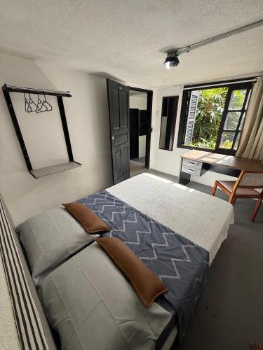 a bedroom with a bed and a desk and a window at Hostel El viajero in Tramandaí