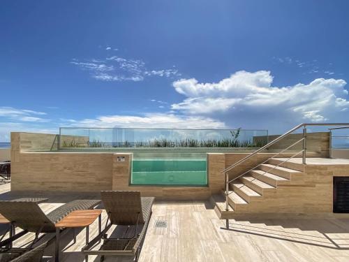 a house with a swimming pool with stairs and chairs at Distrito Puerto by Andiani Travel in Puerto Morelos