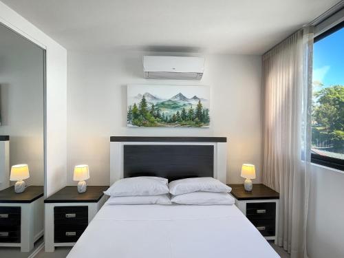 a bedroom with a large white bed and a window at Bay View 2-Bedroom Apartment in Batemans Bay