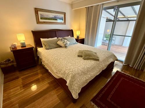 a bedroom with a bed and a window with a view at Coolamon in Ballina