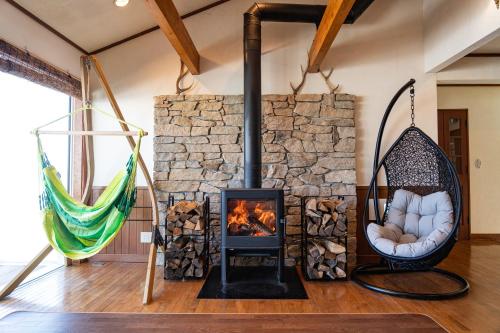 a living room with a fireplace and hammocks at 白樺湖Lake View in Chino
