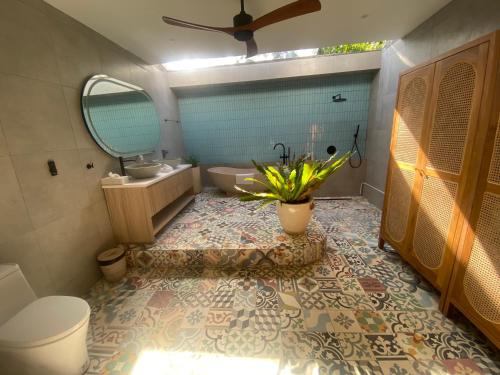a bathroom with a toilet and a sink and a mirror at Villa Alam in Nusa Lembongan