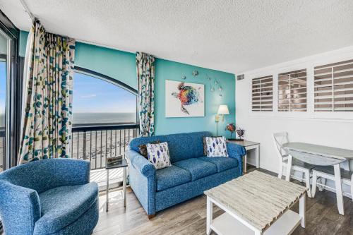 a living room with a blue couch and a table at Beautifully Decorated Condo with Amzing Ocean View in Myrtle Beach