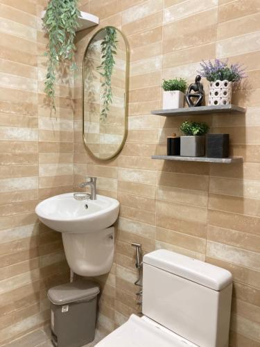 a bathroom with a sink and a toilet and a mirror at Bahay-Kapehan sa Villa in Tambo