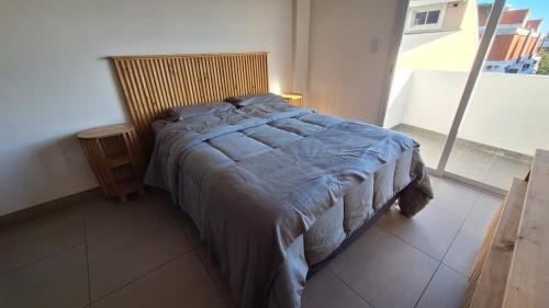 a bedroom with a bed with a wooden head board at Apart Z Alberdi in Belén de Escobar