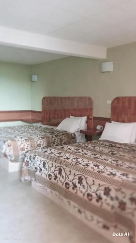 a bedroom with two beds and a table at Campo Real Actopan in Cedro