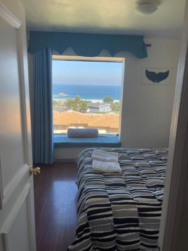 a bedroom with a bed and a large window at Apartamento Playa Mar Azul in El Quisco